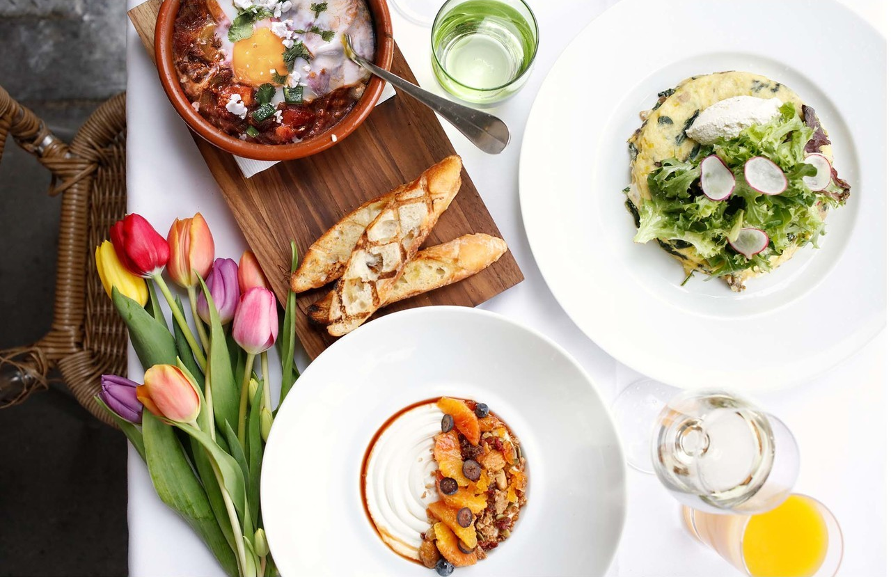 easter brunch dishes on a table with a bundle of tulips from Bar Boulud