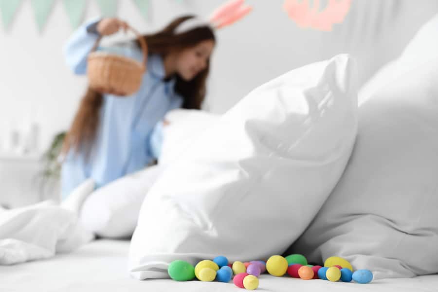 young girl in bunny ears searches for easter eggs in a hotel bed from the Mandarin Oriental New York