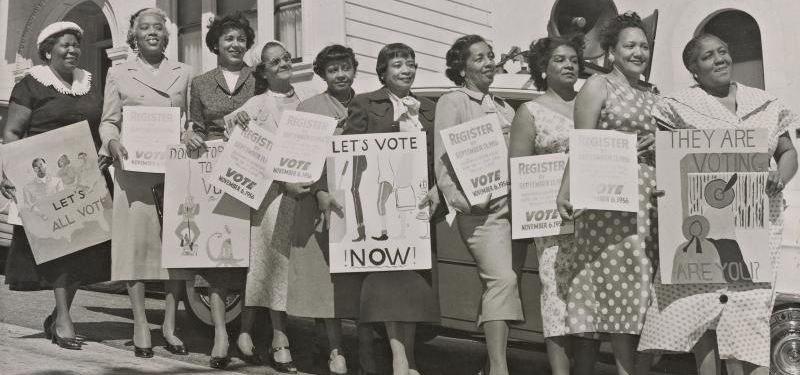 Women activists with signs for registration, 1956