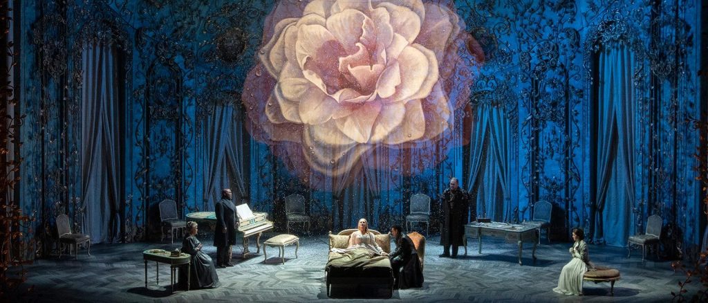 photo of the cast performing a scene from La Traviata on-stage at the Met Opera
