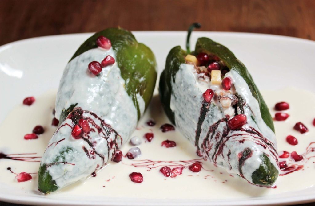 Poblano Peppers covered in peanut sauce with pomegranate seeds