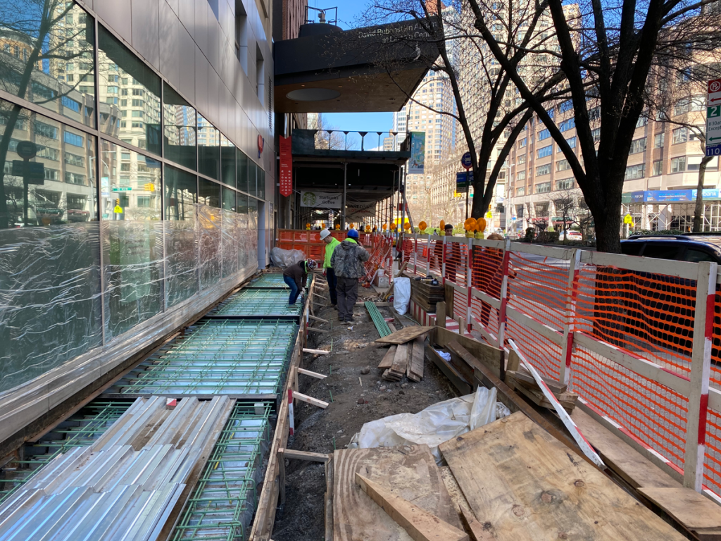 construction workers doing repair work on the sidewalk in front of the AAA building on Broadway
