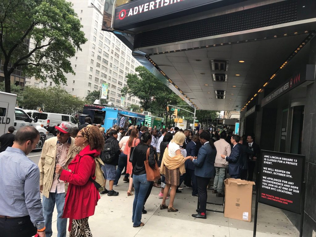 people gather in a crowd on the sidewalk in front of AMC Lincoln Center for Ad Week 2018