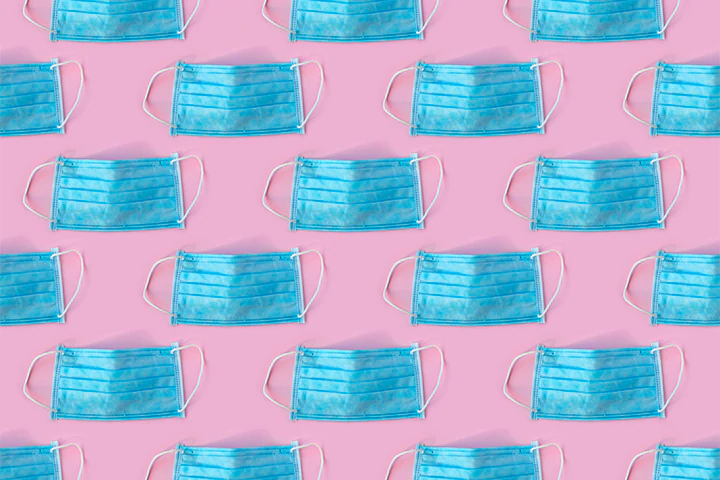 blue medical masks on a pink background