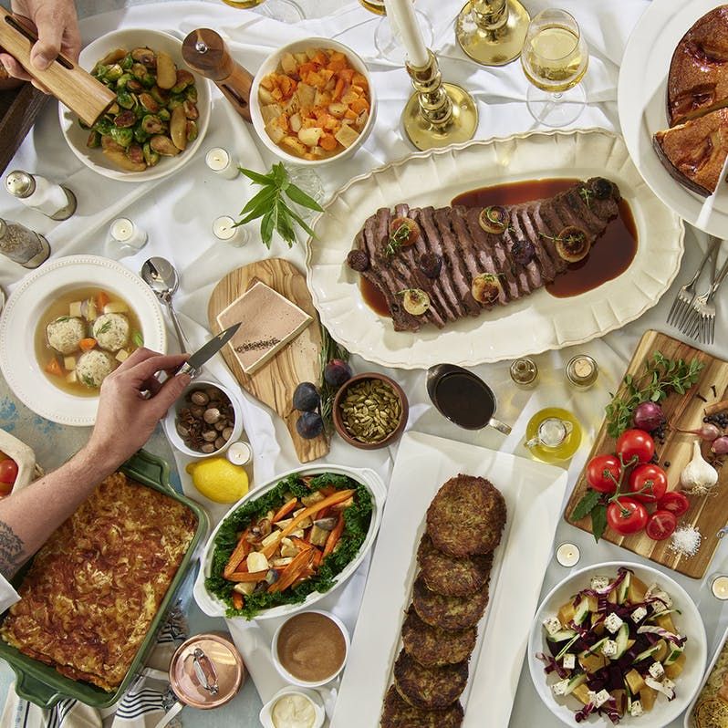 a spread of foods for Rosh Hashanah placed across a dinner table