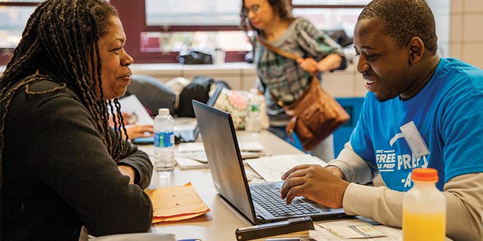 a Tax-Aide rep helps a woman complete her taxes inside of a library