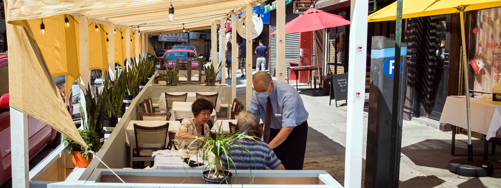 a waiter serving diners outside