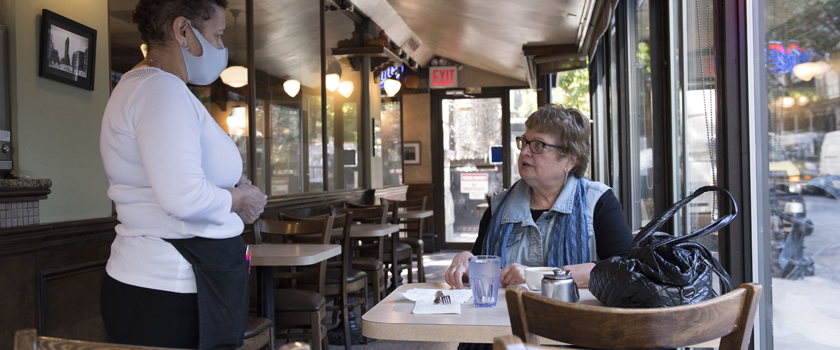 diner and waiter interacting inside a restaurant during the covid19 pandemic