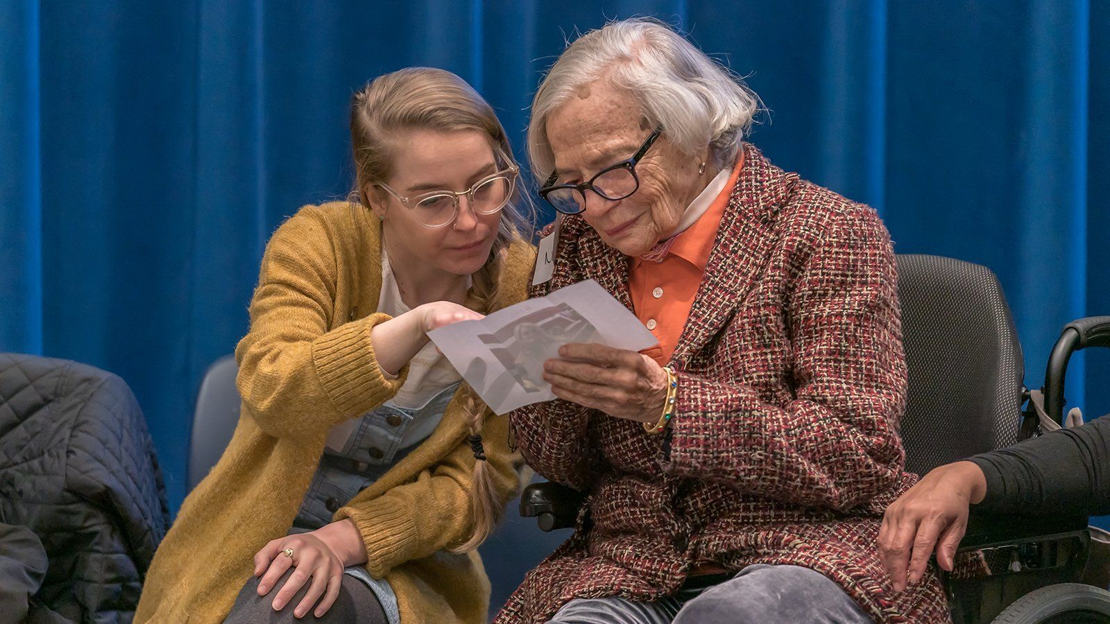 girl showing photo to older woman