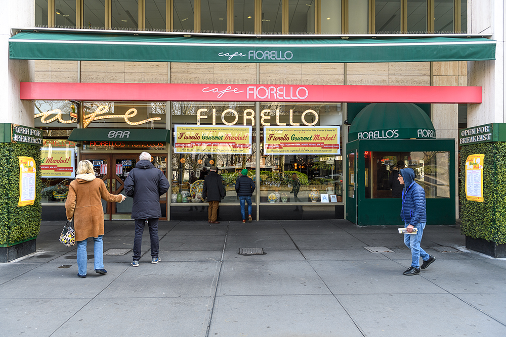 People wait for takeout outside of Cafe Fiorellos during the COVID-19 crisis