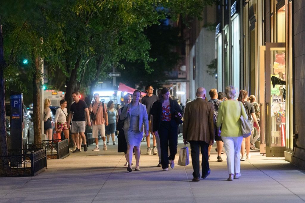 pedestrians walking down broadway in Lincoln Square on a fall evening