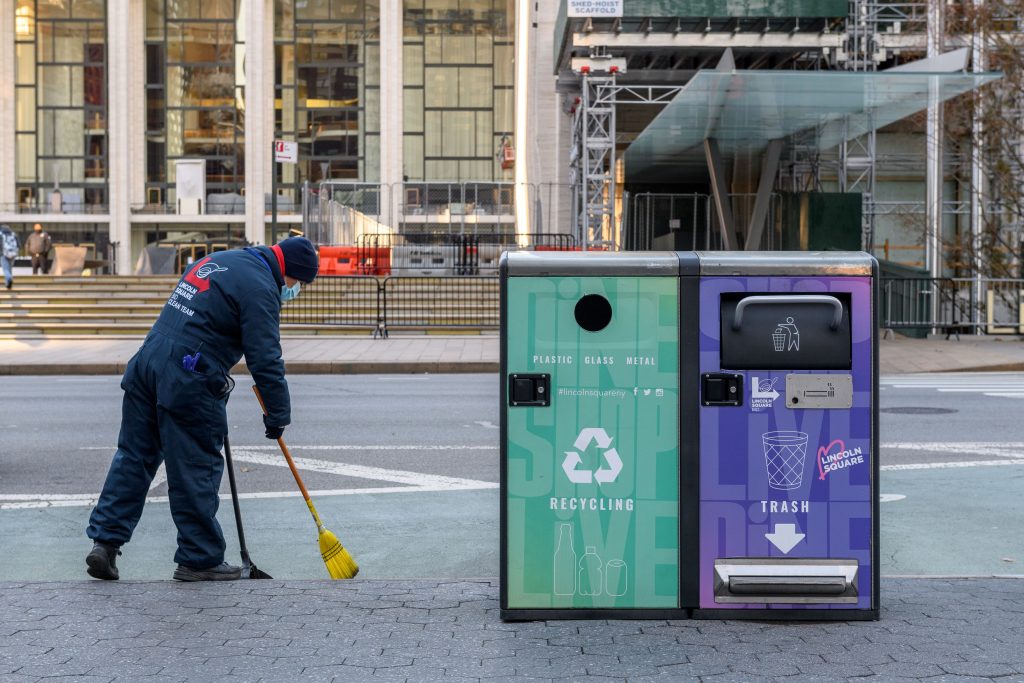 clean team member sweeping sidewalk