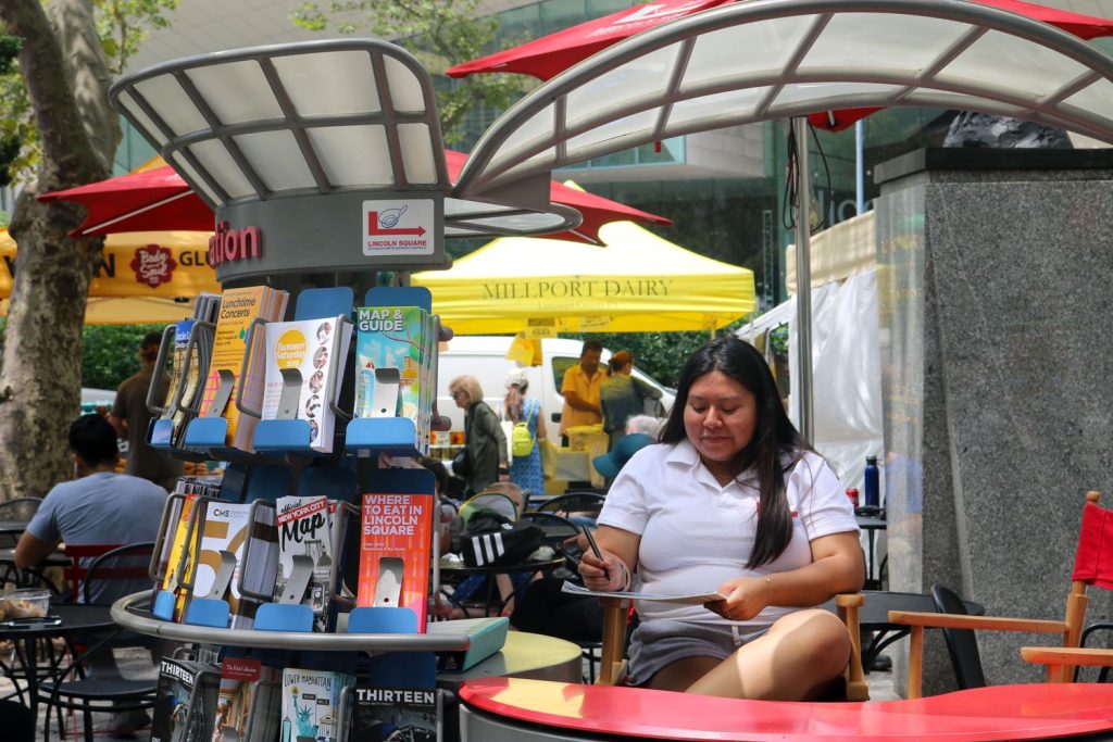 An Information Ambassador  takes notes at an Information Cart in Richard Tucker Park