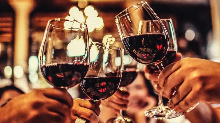 hands cheersing with wine glasses