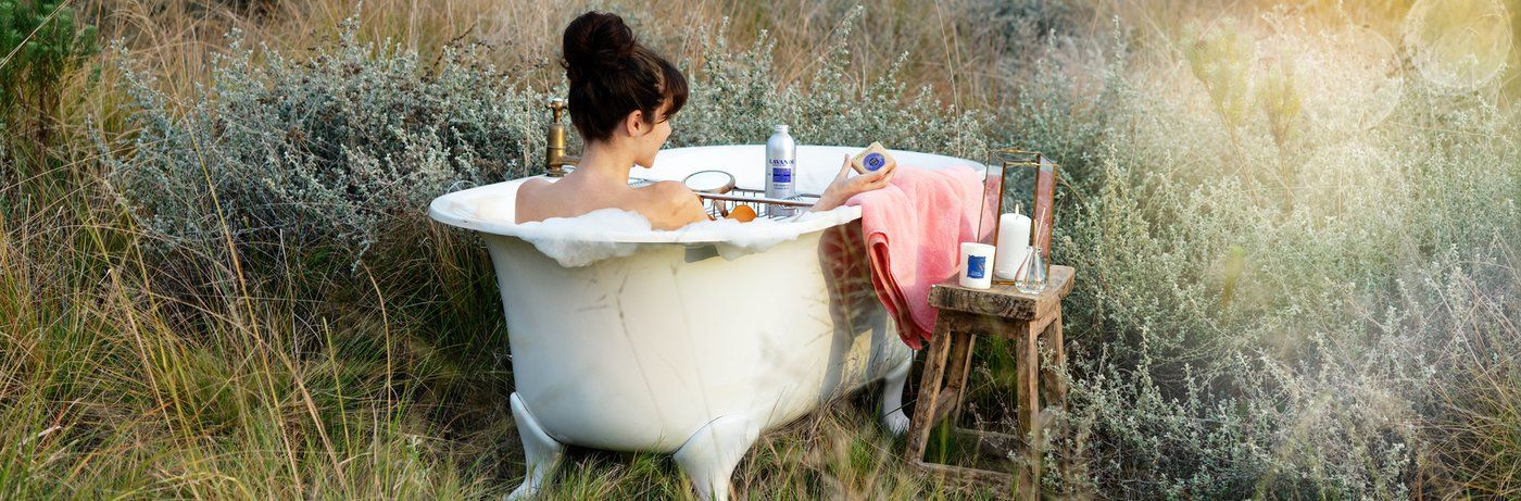 woman in a claw tub bath enjoys herself with luxury products