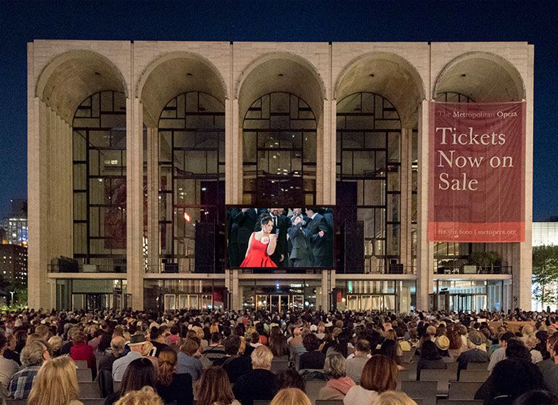 a crowd of people gathers on Lincoln Center_s plaza to watch a free screening