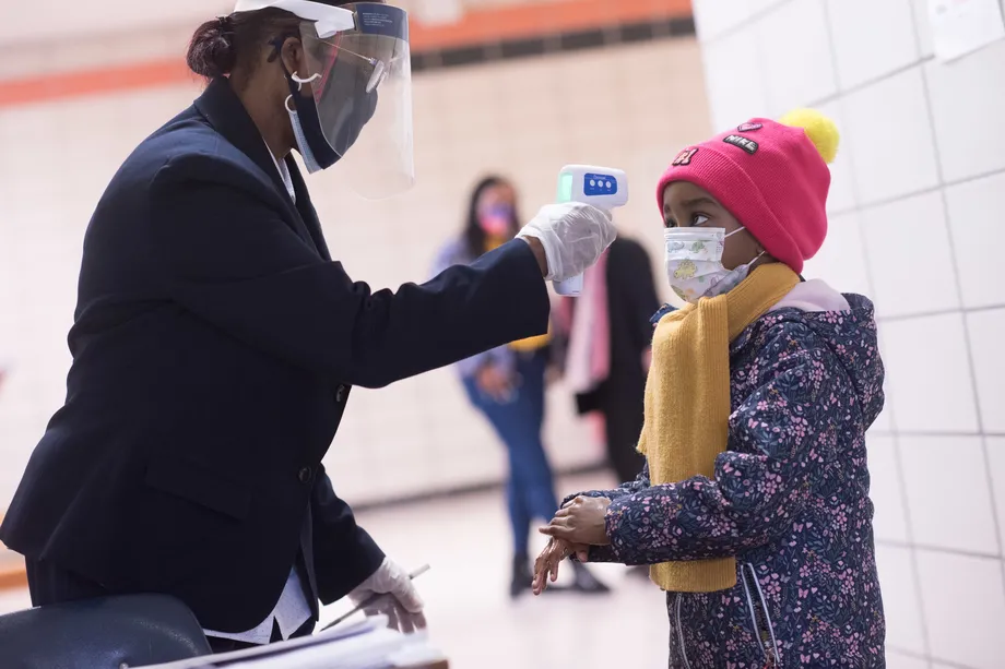 school staff checking the temperature of a student