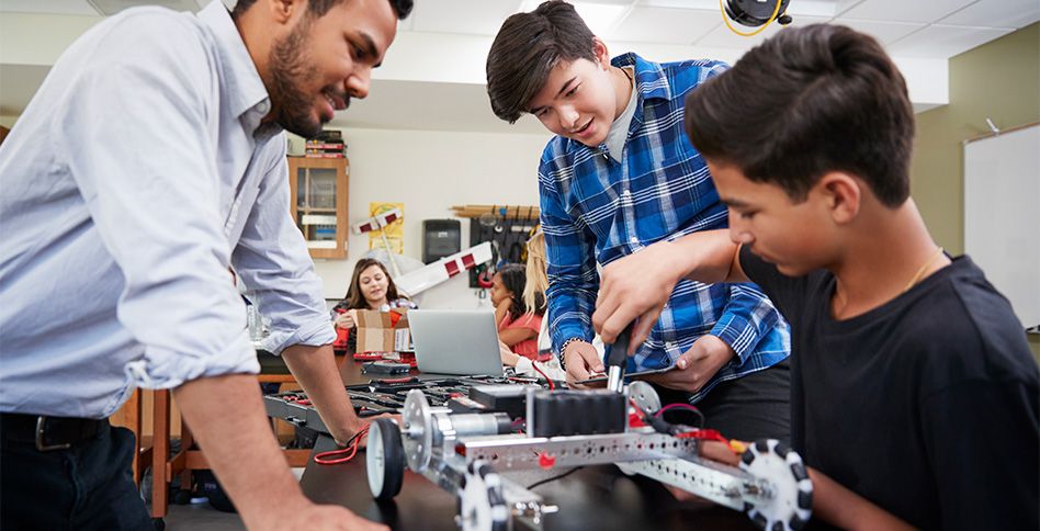 teacher helping kids with a STEM project