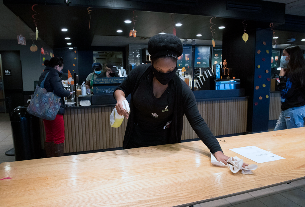 a worker inside of the Starbucks at 63rd St and Broadway wipes down a counter top for patrons with disinfectant