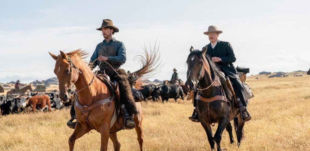 still shot from The Power of the Dog with two men on horseback in a field