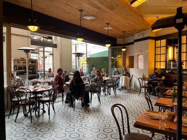 some partons dine inside at The Smith for breakfast by the front windows which have been opened for nice weather