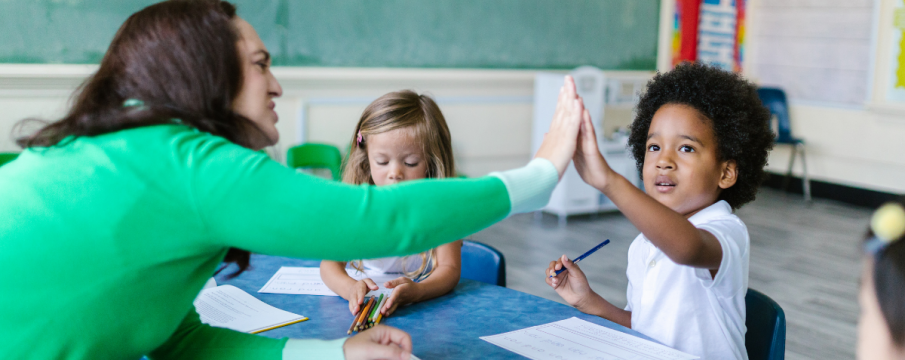 Photo of a teacher giving a high five to a student