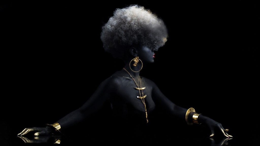 Photo of woman painted black wearing gold jewelry designed by Douriean Fletcher