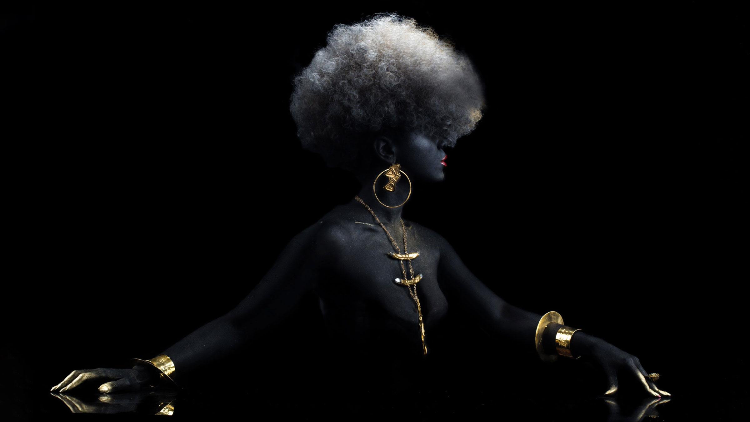 Photo of woman painted black wearing gold jewelry designed by Douriean Fletcher