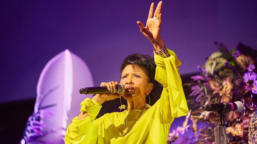 Photo of a singer with an arm raised