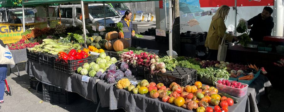 Photo of a table full of different types of vegetables at a farmers market